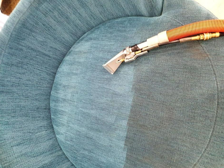A Blue Couch Is Being Cleaned With A Vacuum Cleaner — Pinnacle Carpet & Upholstery Cleaning In Wyong, NSW