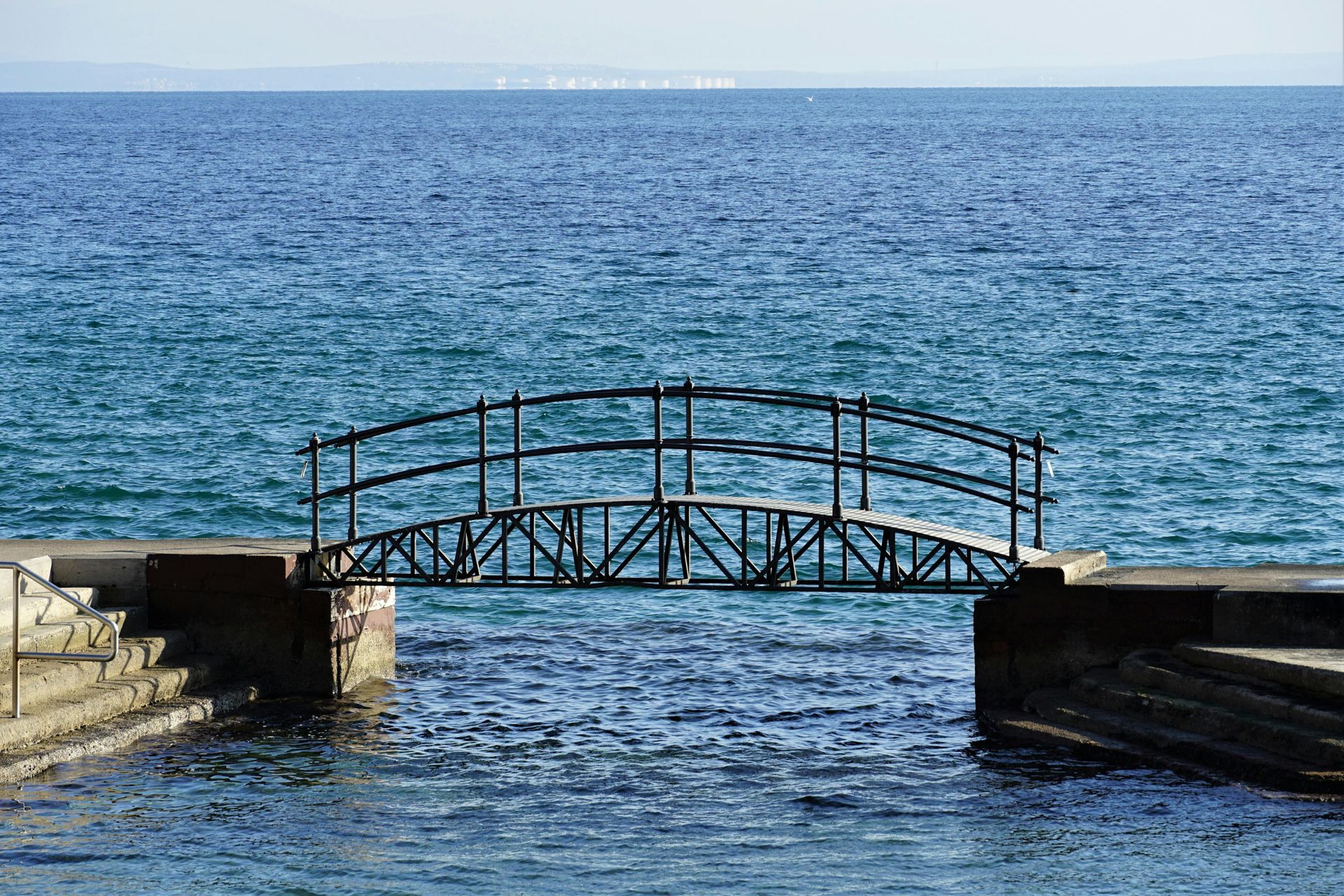 metal bridge spanning opening between harbor and lake superior