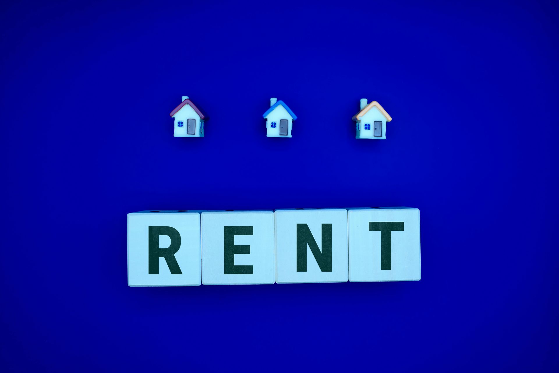 blue background with RENT spelt out in blocks under 3 houses