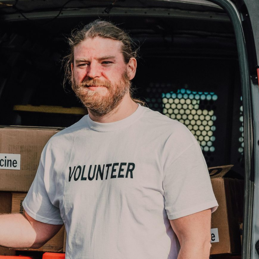 Man with beard standing at the back of a cargo van