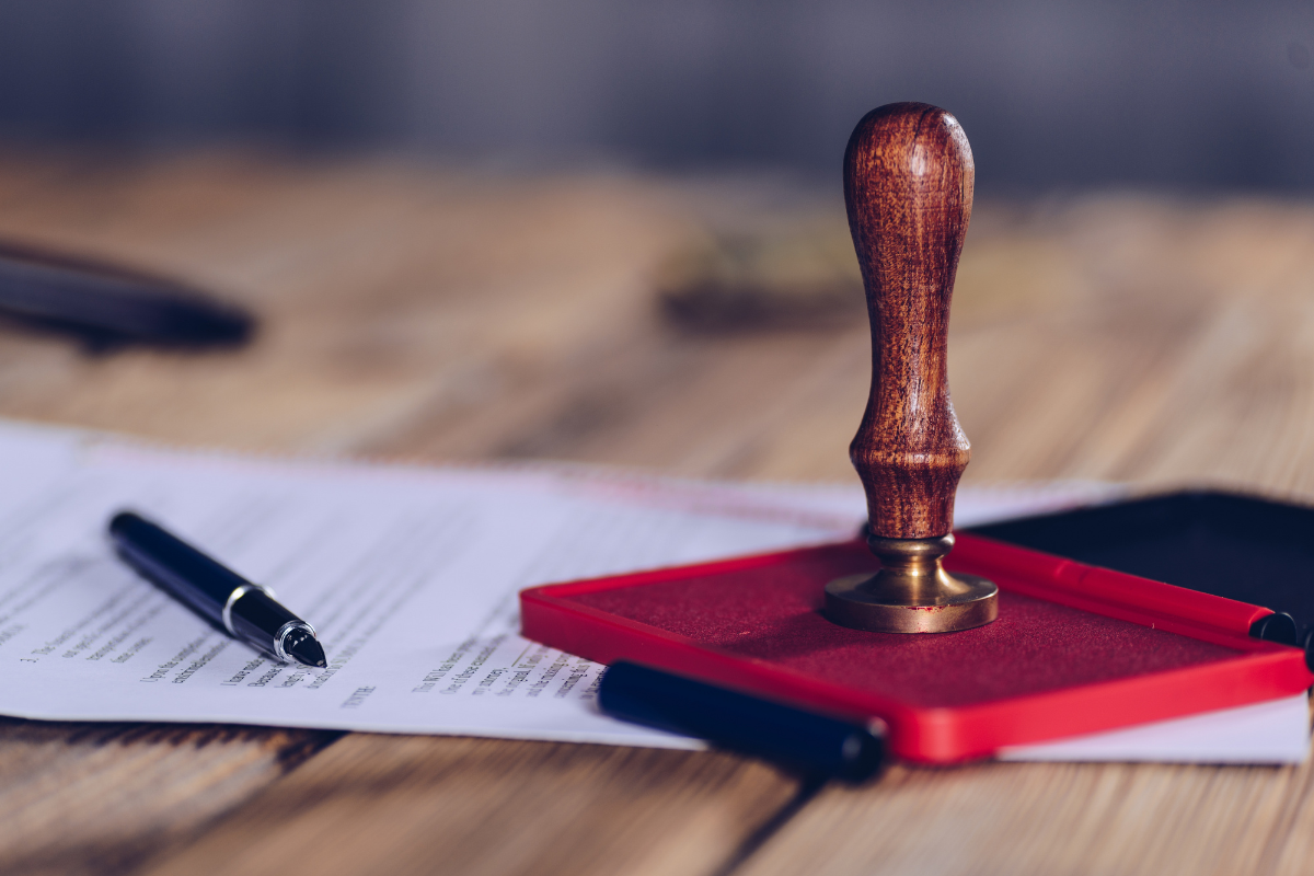 Wooden stamp on a document with text, on a wooden table.