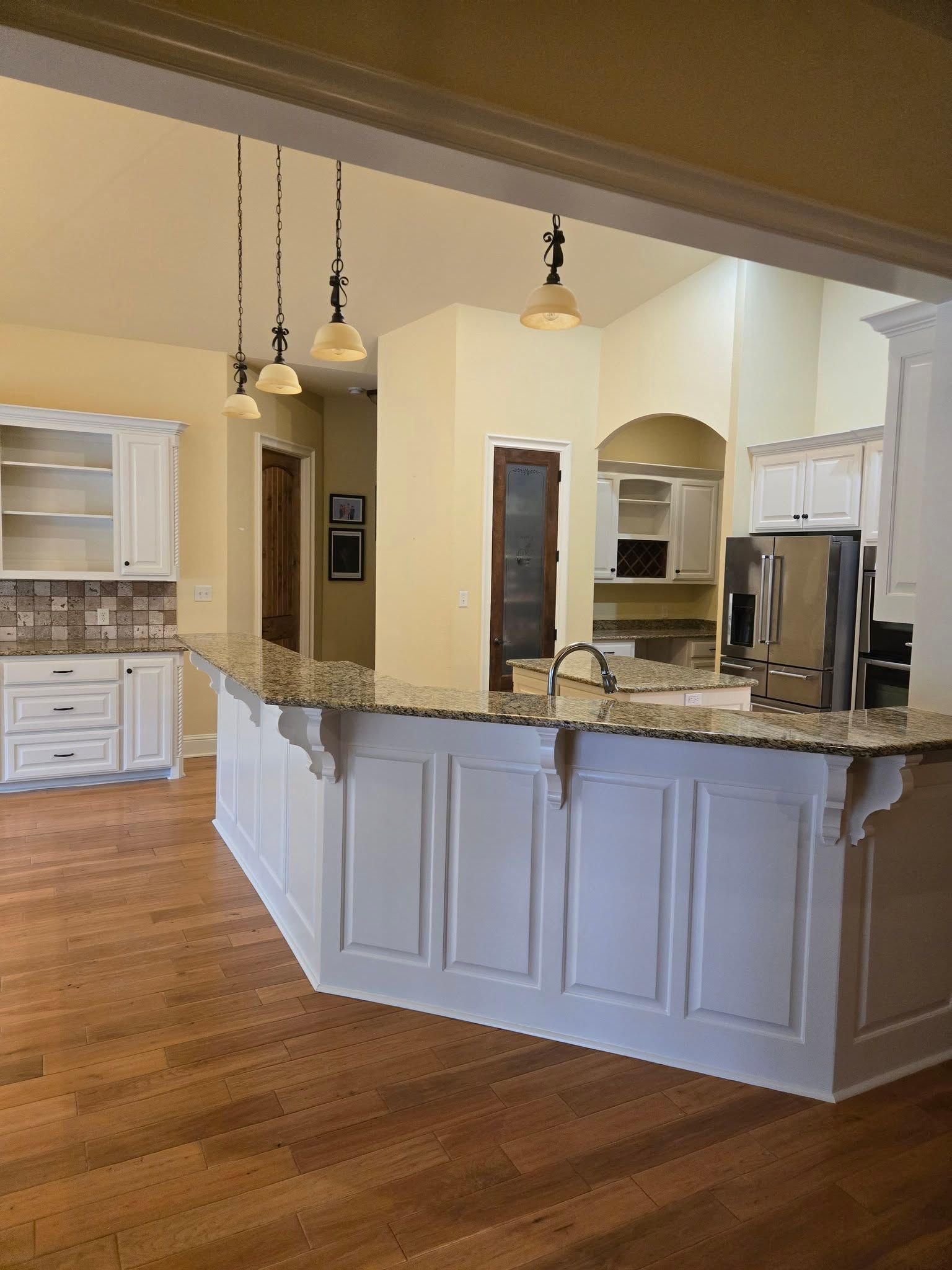 A kitchen with white cabinets and granite counter tops