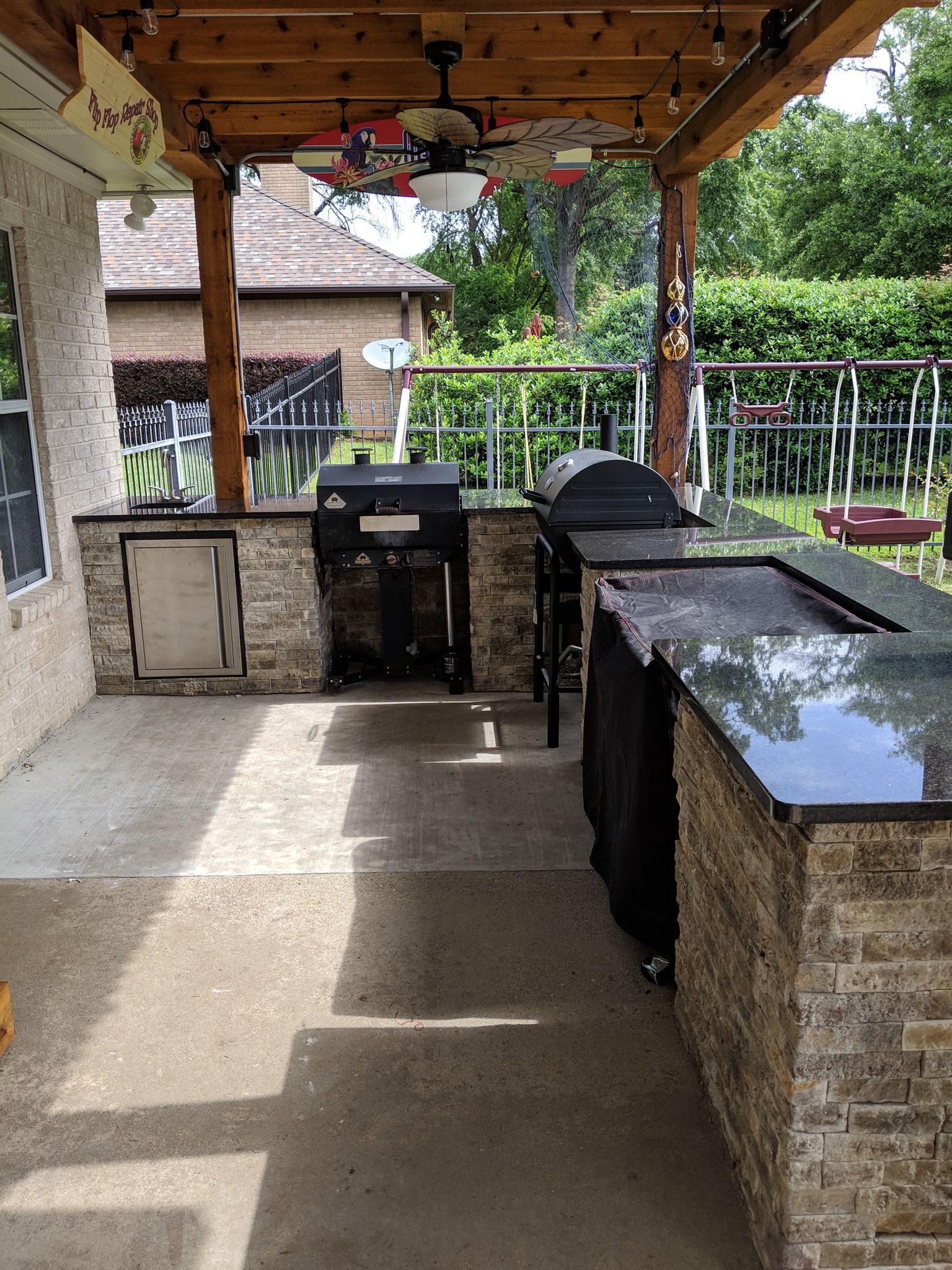 A patio with a grill and a ceiling fan