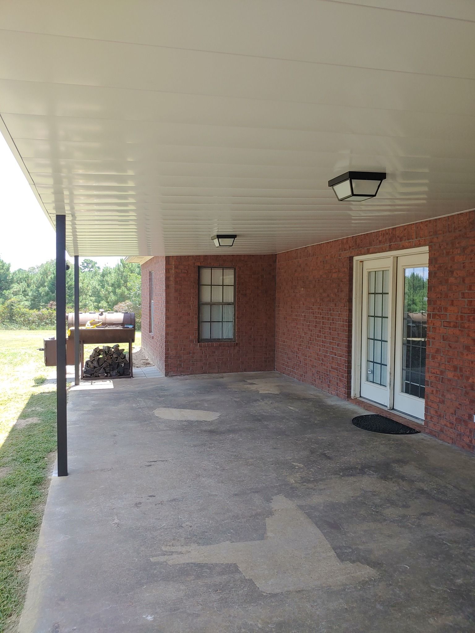 A brick house with a covered porch and sliding glass doors.