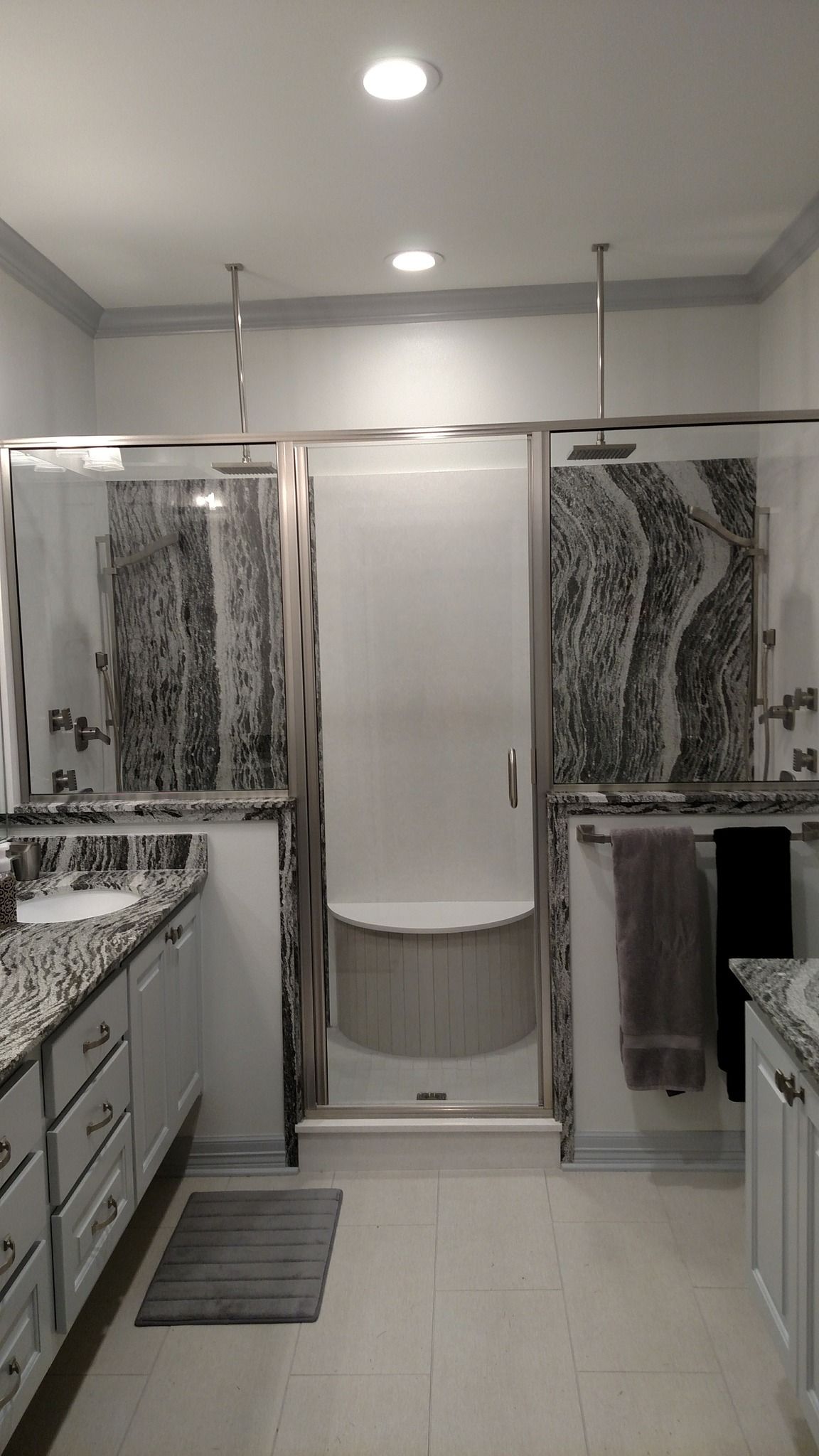 A bathroom with a walk in shower , sink , and mirror.