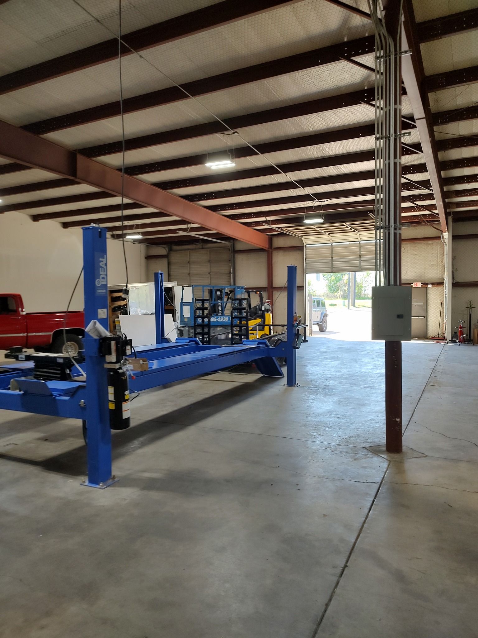 A large warehouse with a blue lift in the middle of it.