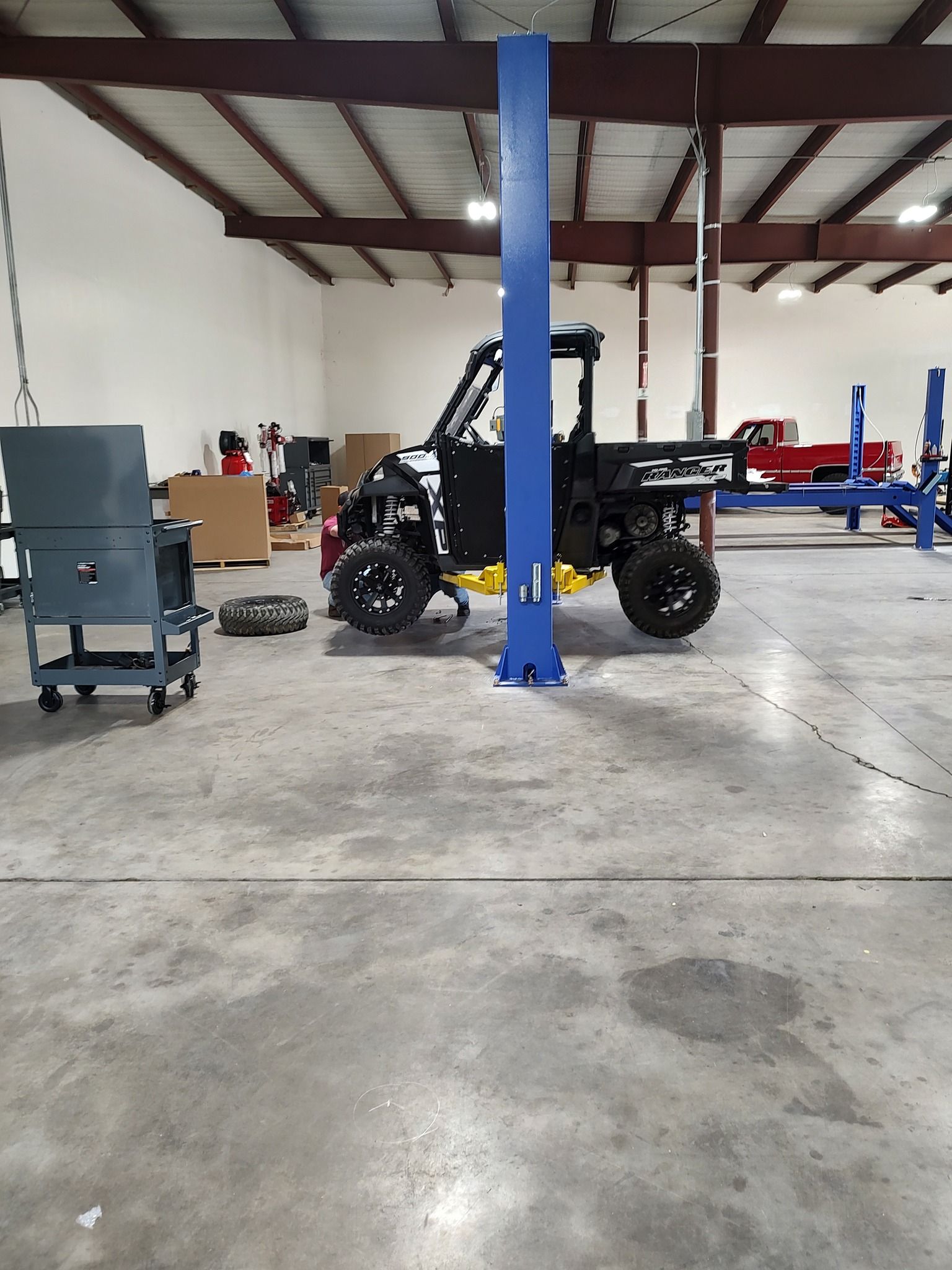 A delivery man in a red shirt is writing on a clipboard