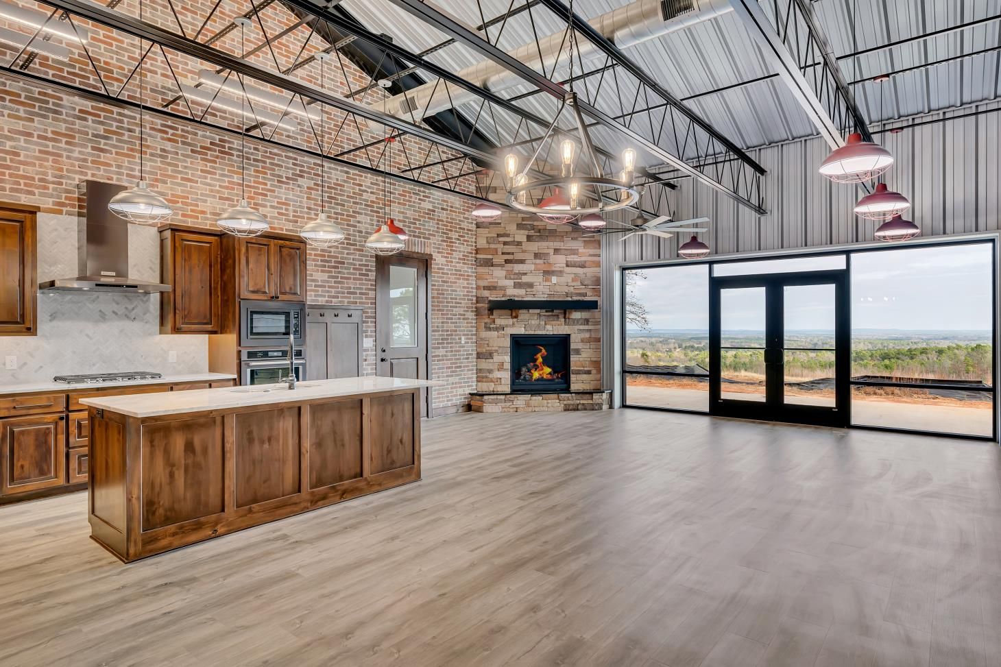 A kitchen with a large island and a fireplace in a large room.