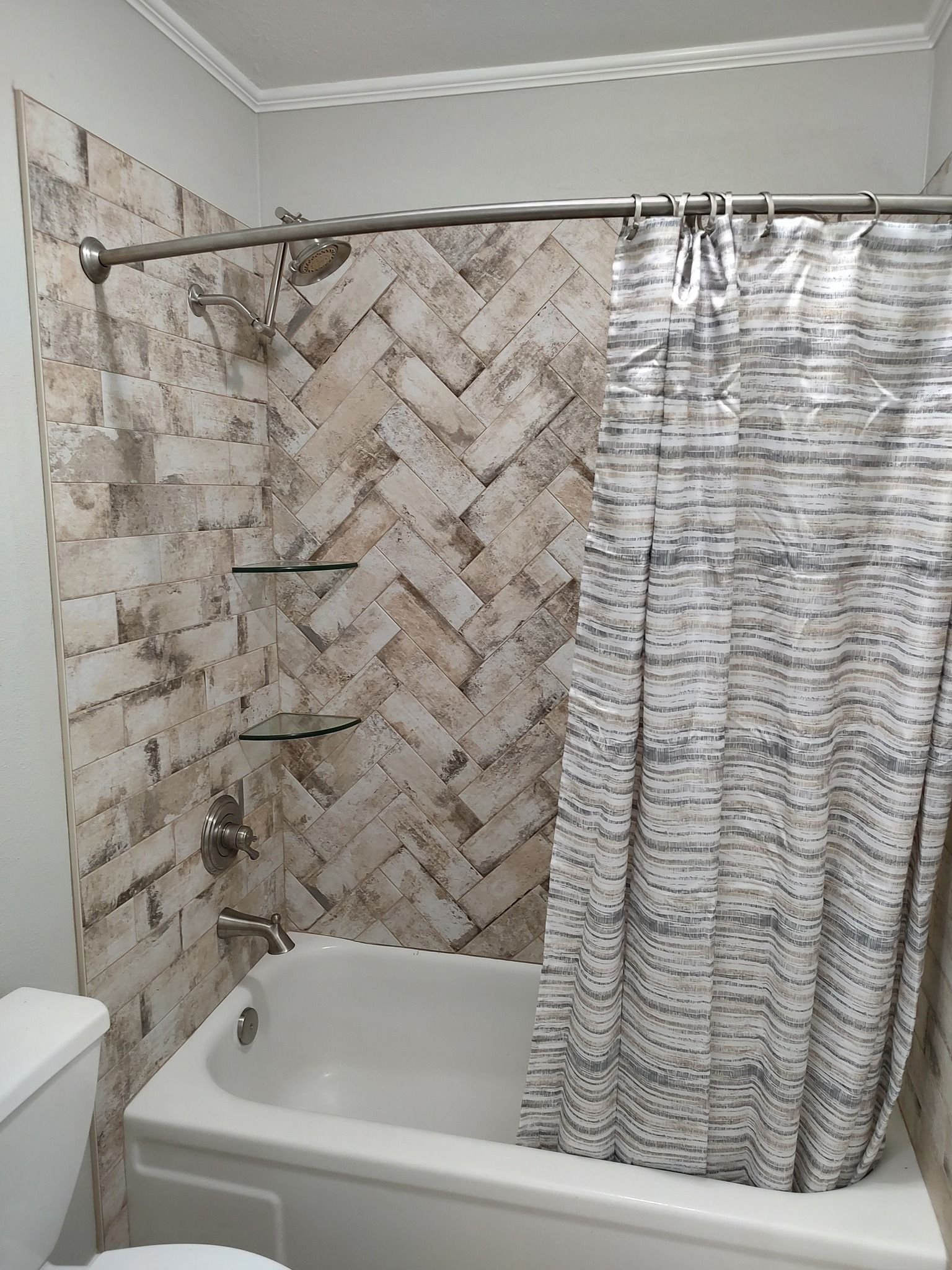 A bathroom with a bathtub , toilet and shower curtain.
