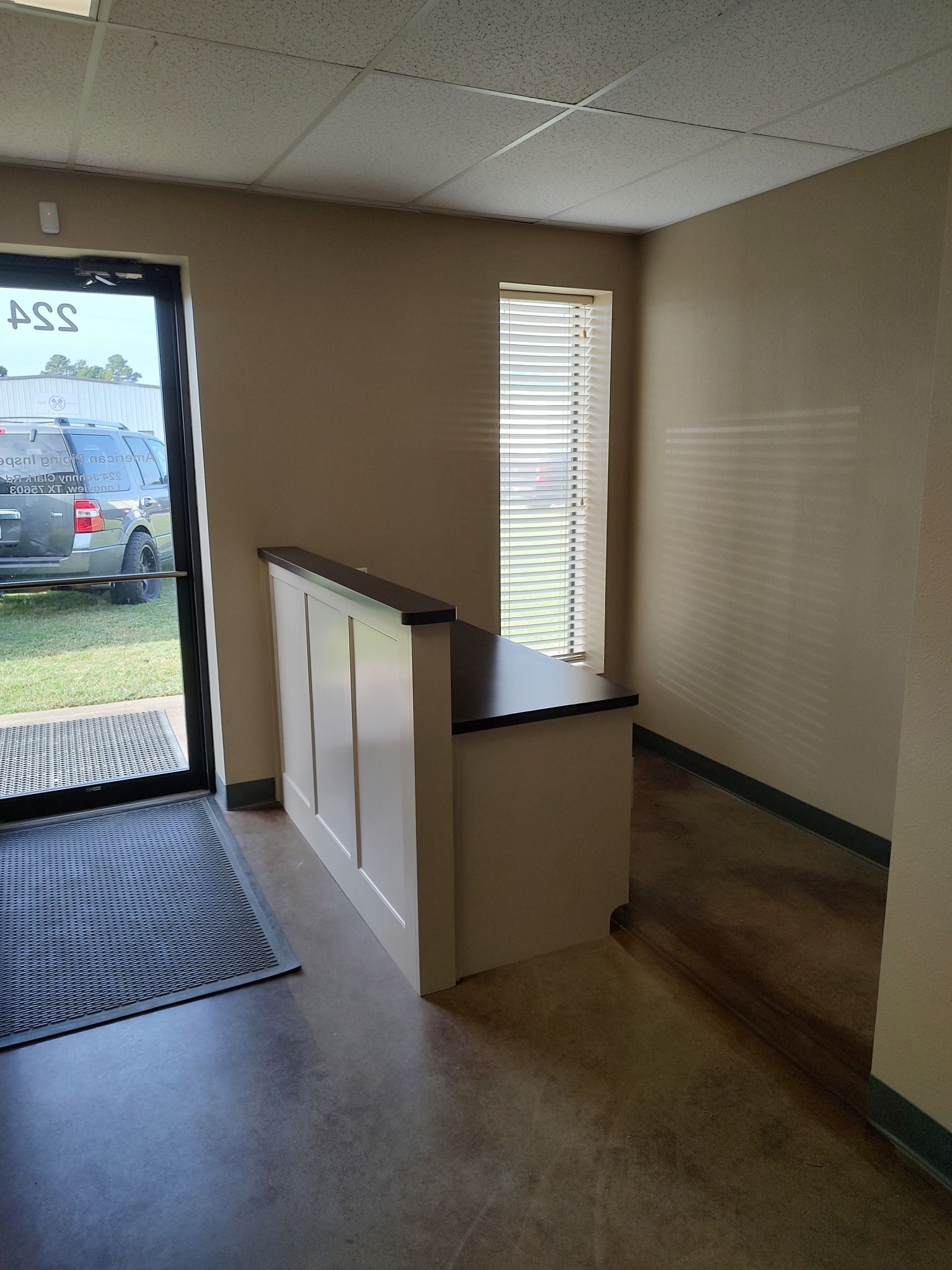 A reception area in a building with a car parked in the background.