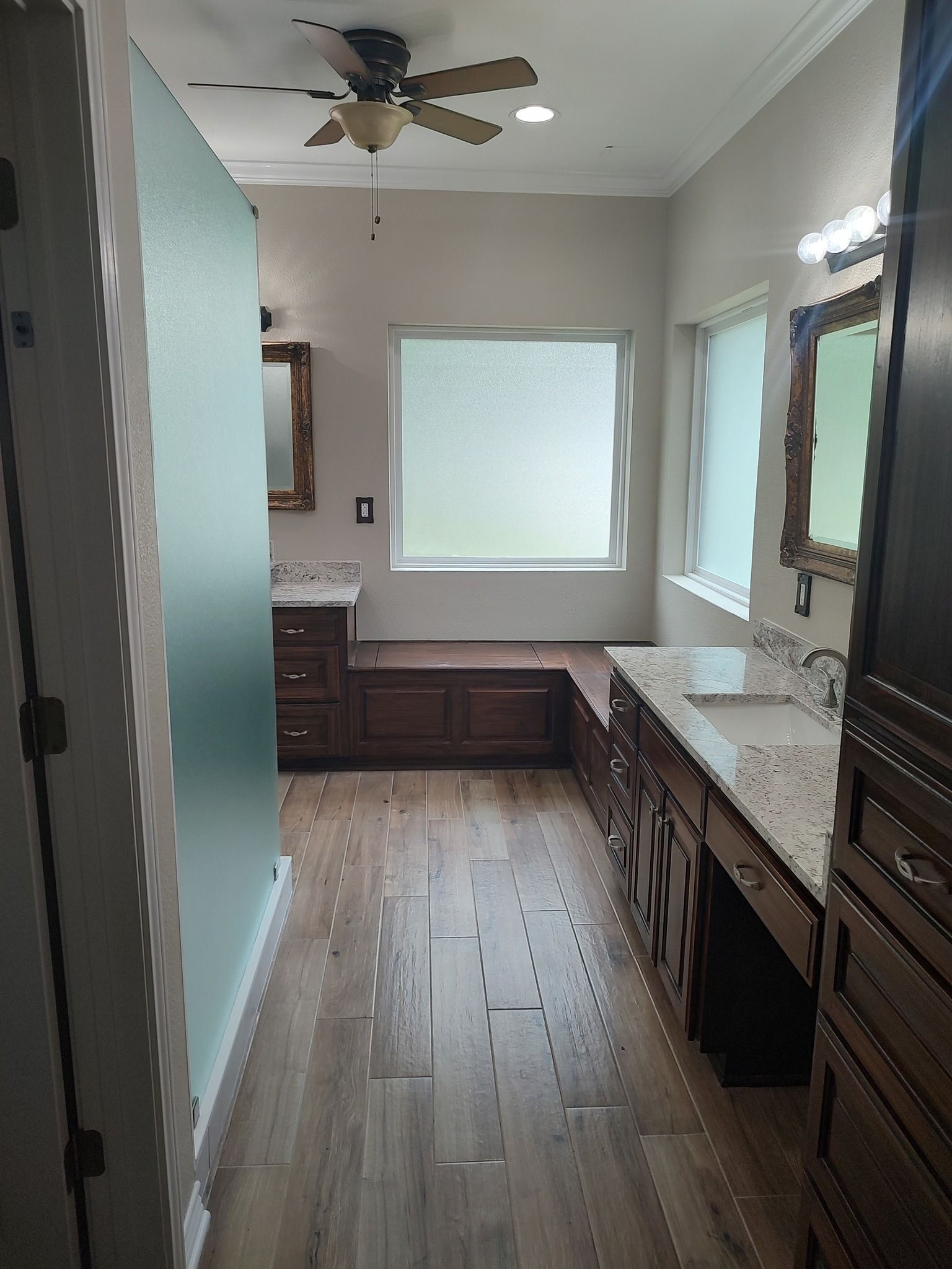 A bathroom with two sinks , a mirror and a ceiling fan.
