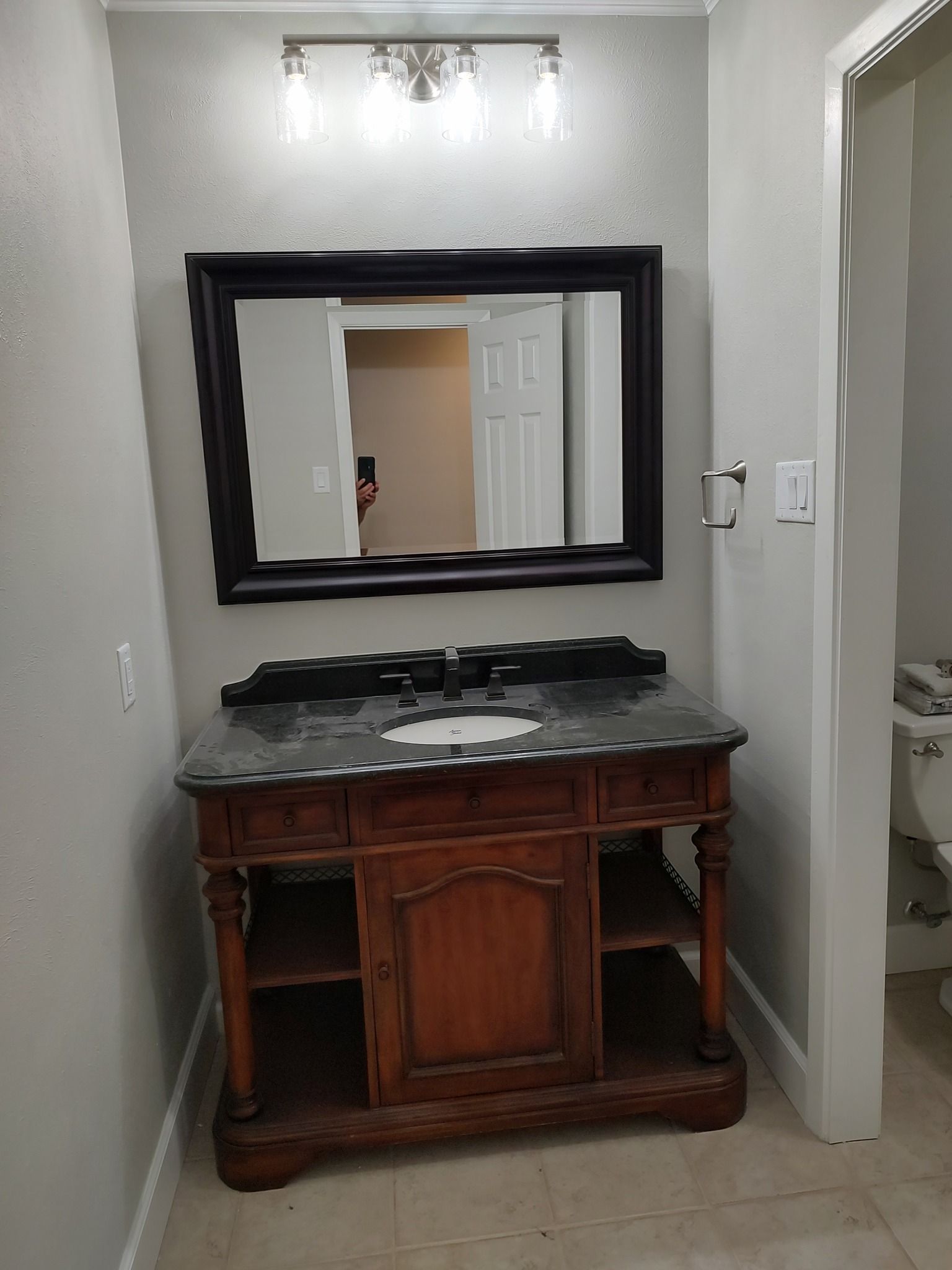 A bathroom with a sink , mirror and vanity.