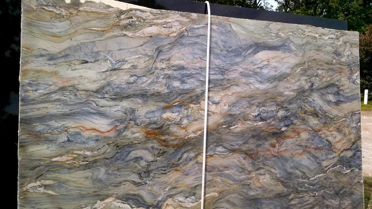 A large piece of marble is sitting on top of a table next to a ruler.