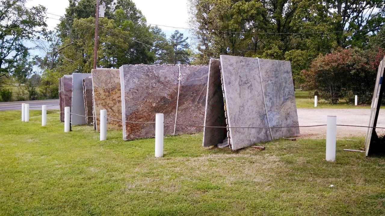 A row of granite slabs sitting on top of a lush green field.