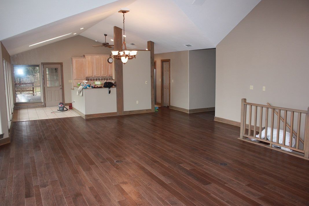 An empty living room with hardwood floors and a staircase