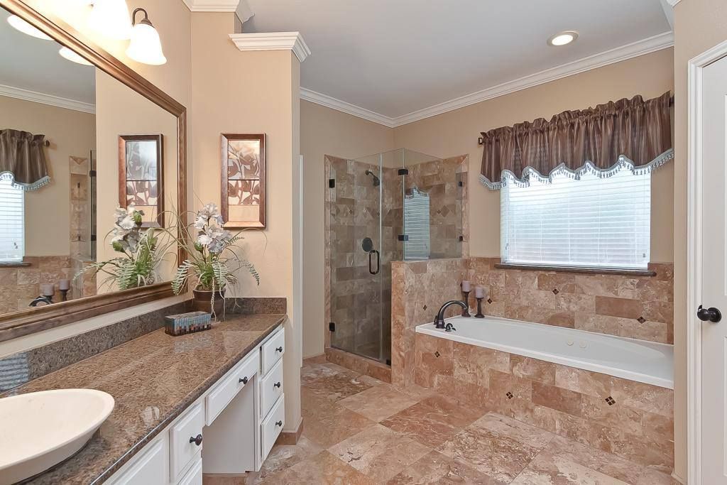 A bathroom with a tub a sink and a mirror