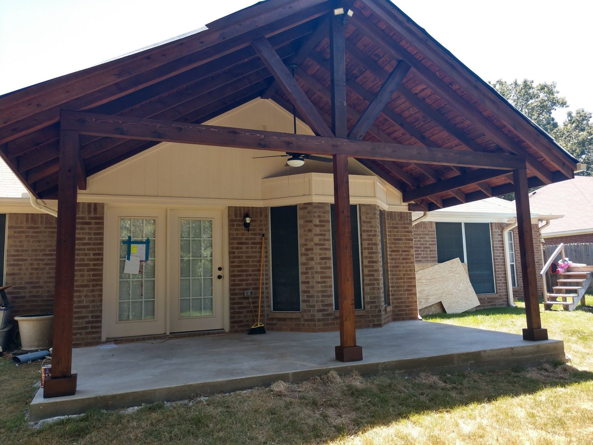 A brick house with a wooden porch and a ceiling fan