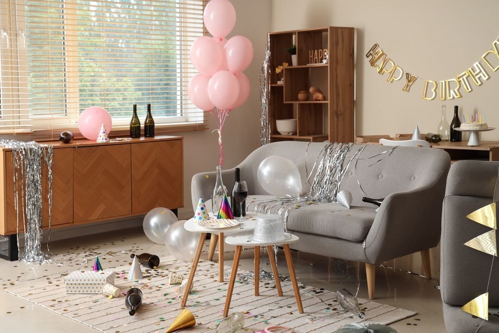 Birthday party living room with pink balloons, silver decorations, and a “Happy Birthday” banner.