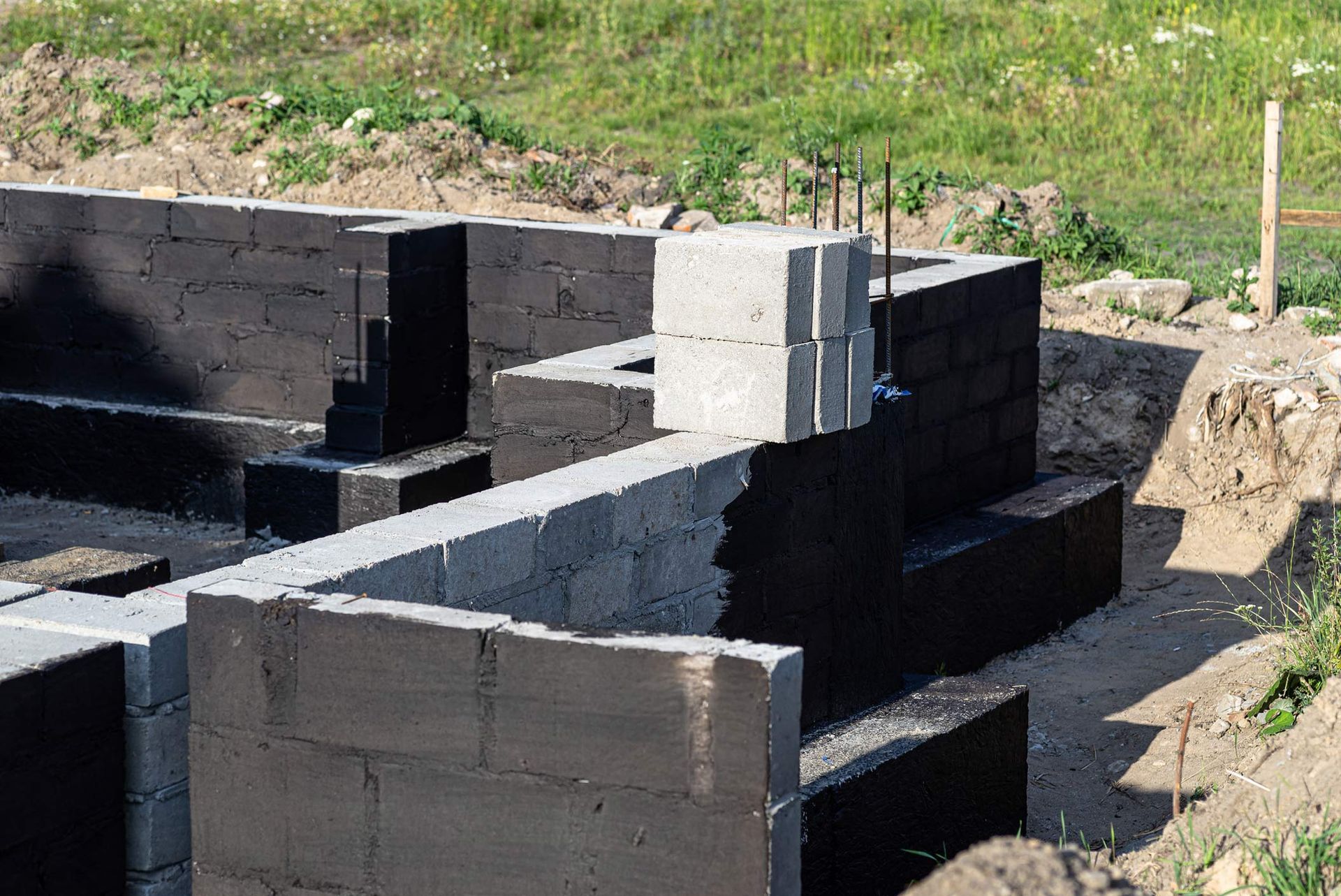 Partially constructed building foundation with concrete blocks outdoors.