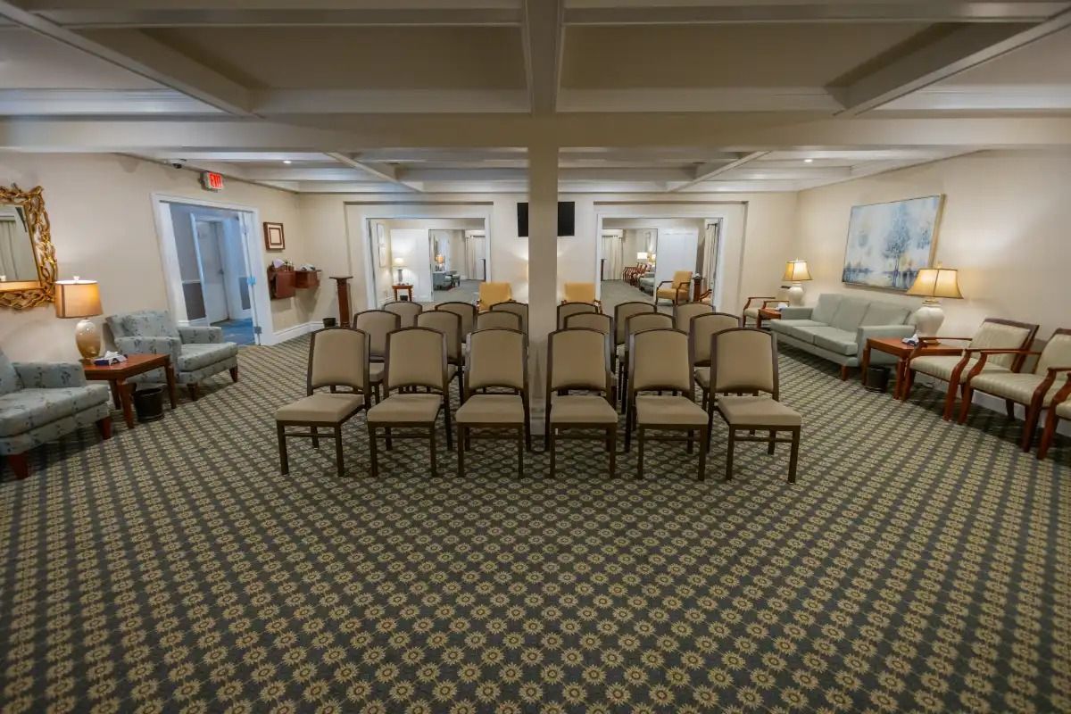 Interior view of a funeral home's seating area with rows of chairs facing the front.