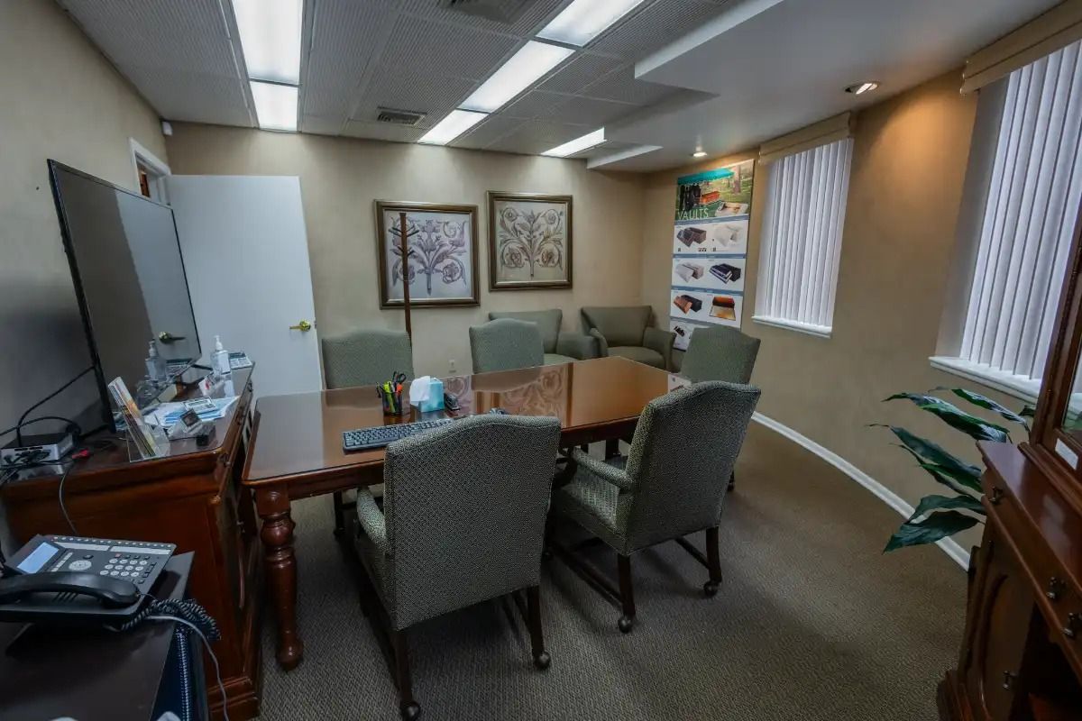 An office with a conference table, chairs, and artwork on the walls.