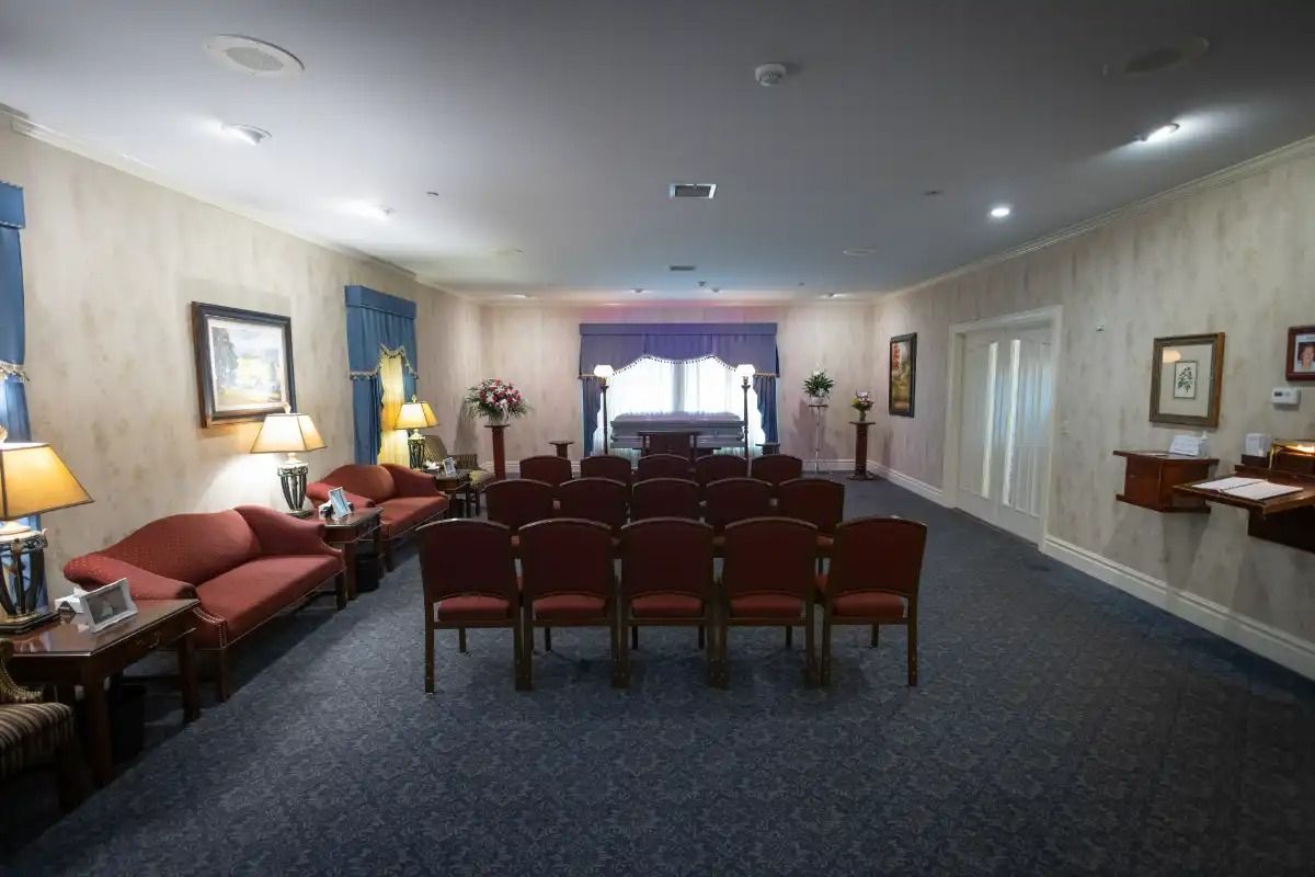 Interior view of a funeral home chapel with red chairs and couches.