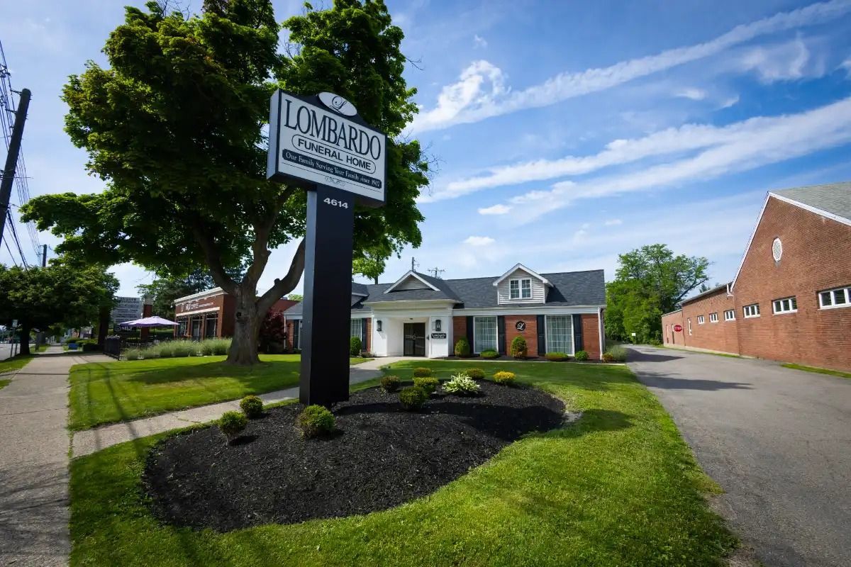 Sign for Longhurst Funeral Home in front of a white building with black shutters.