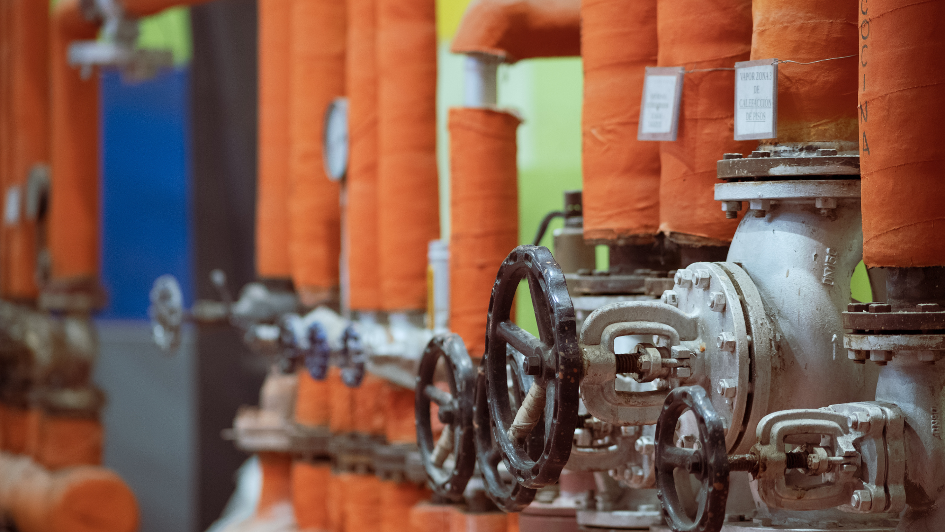 A row of pipes and valves in a factory.