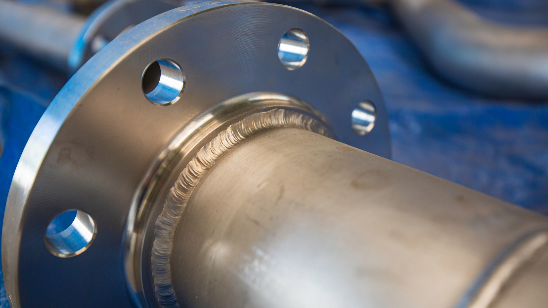 A close up of a stainless steel pipe with a flange on it.