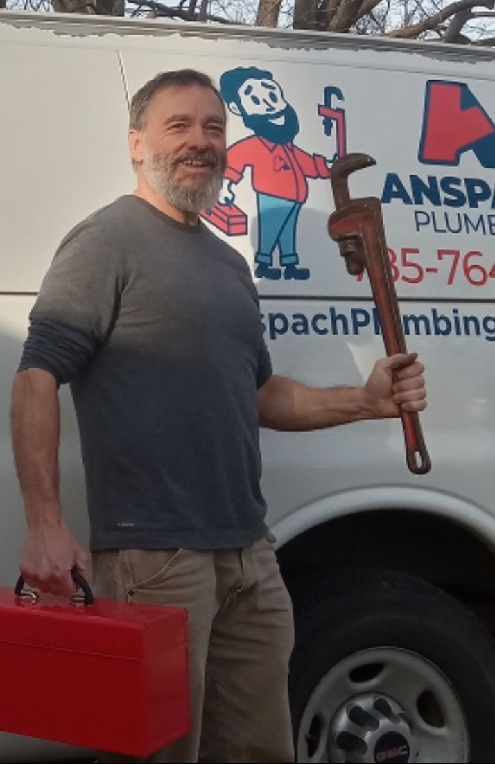 Funny picture of Todd Anspach holding up a wrench and a red toolbox next to his van.
