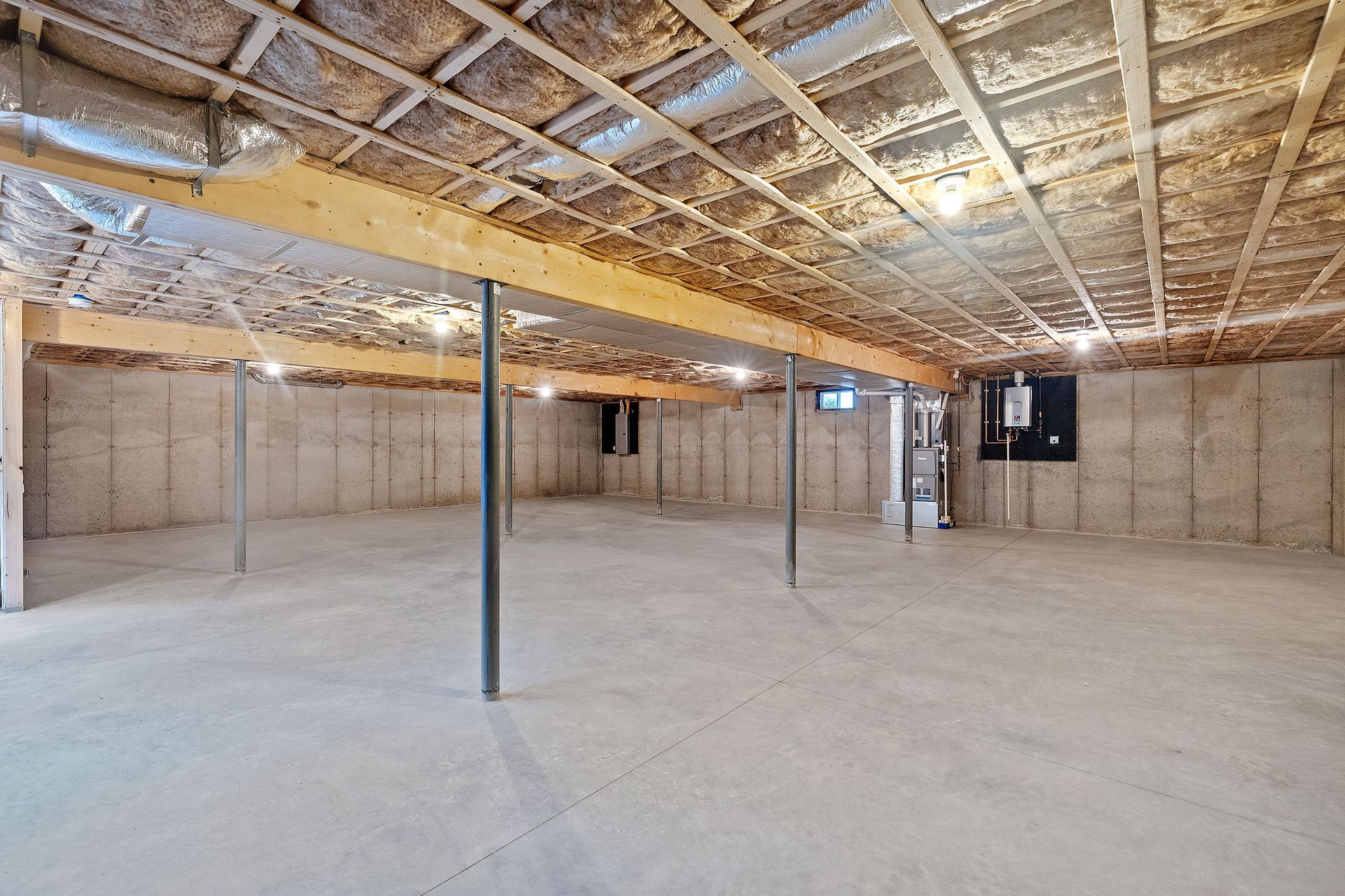 Large open basement with finished concrete floor containing radiant floor heating.