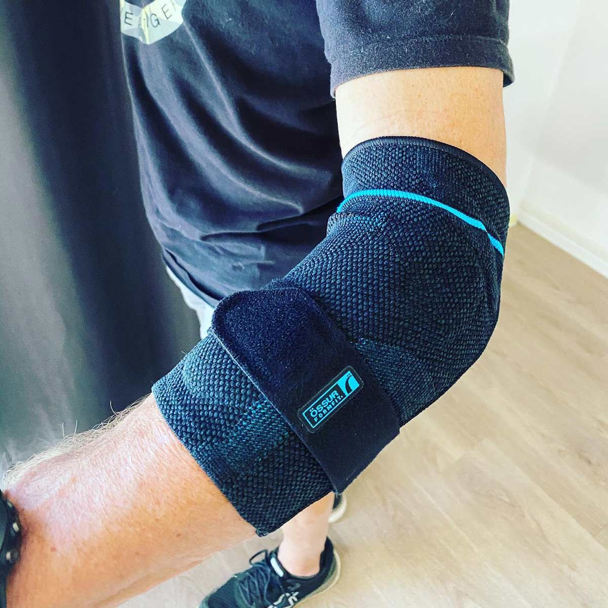 A Man Wearing a Black Elbow Brace With the Word Delta on It — Gall Bros Medical in Robina, QLD