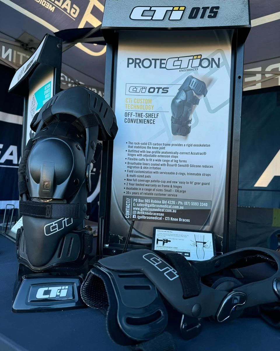 A Pair of Knee Pads Sitting on Top of a Table Next to a Sign That Says Protection — Gall Bros Medical in Robina, QLD