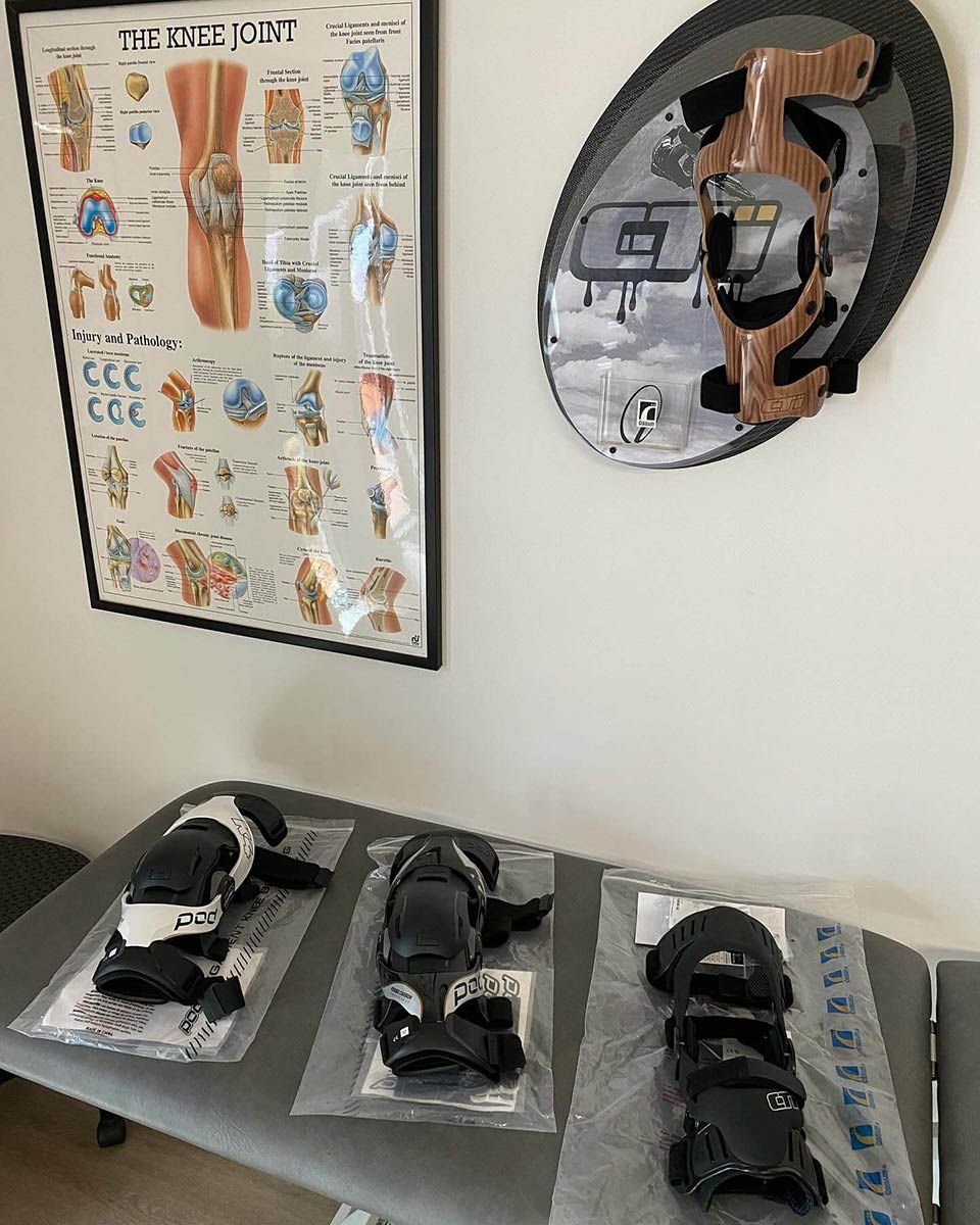 A Table With Knee Pads on It and a Poster on the Wall — Gall Bros Medical in Robina, QLD