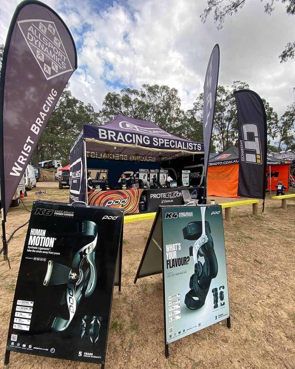 A Bunch of Signs Are Sitting in the Dirt in Front of a Tent — Gall Bros Medical in Robina, QLD