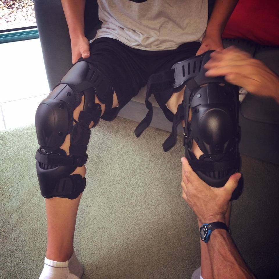 A Person Wearing Knee Pads is Being Held by Another Person — Gall Bros Medical in Robina, QLD