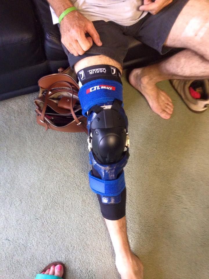 A Person is Sitting on a Couch With a Knee Brace on Their Leg — Gall Bros Medical in Robina, QLD