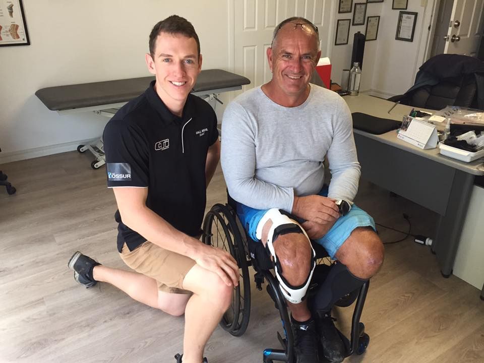 Shaun With Man In Wheelchair With Brace on Knee — Gall Bros Medical in Robina, QLD