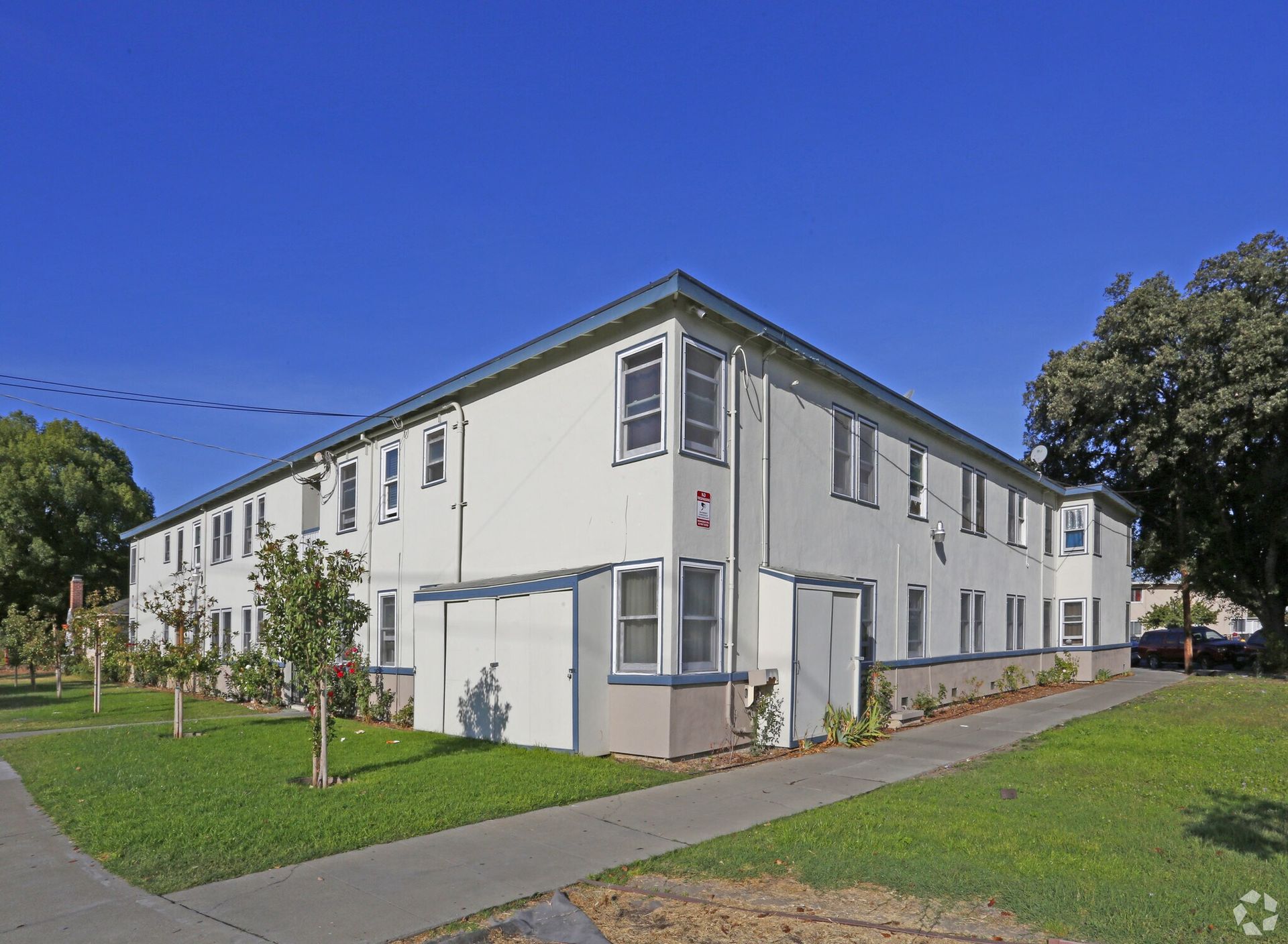 Modern multi-story apartment building with balconies and large windows.