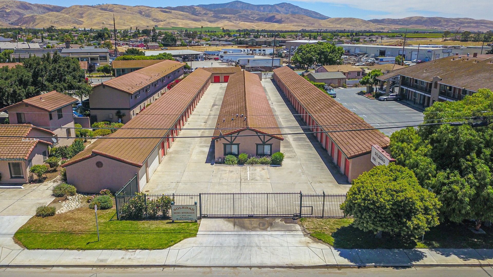Man in gray suit and blue shirt smiles, headshot against a gray backdrop.