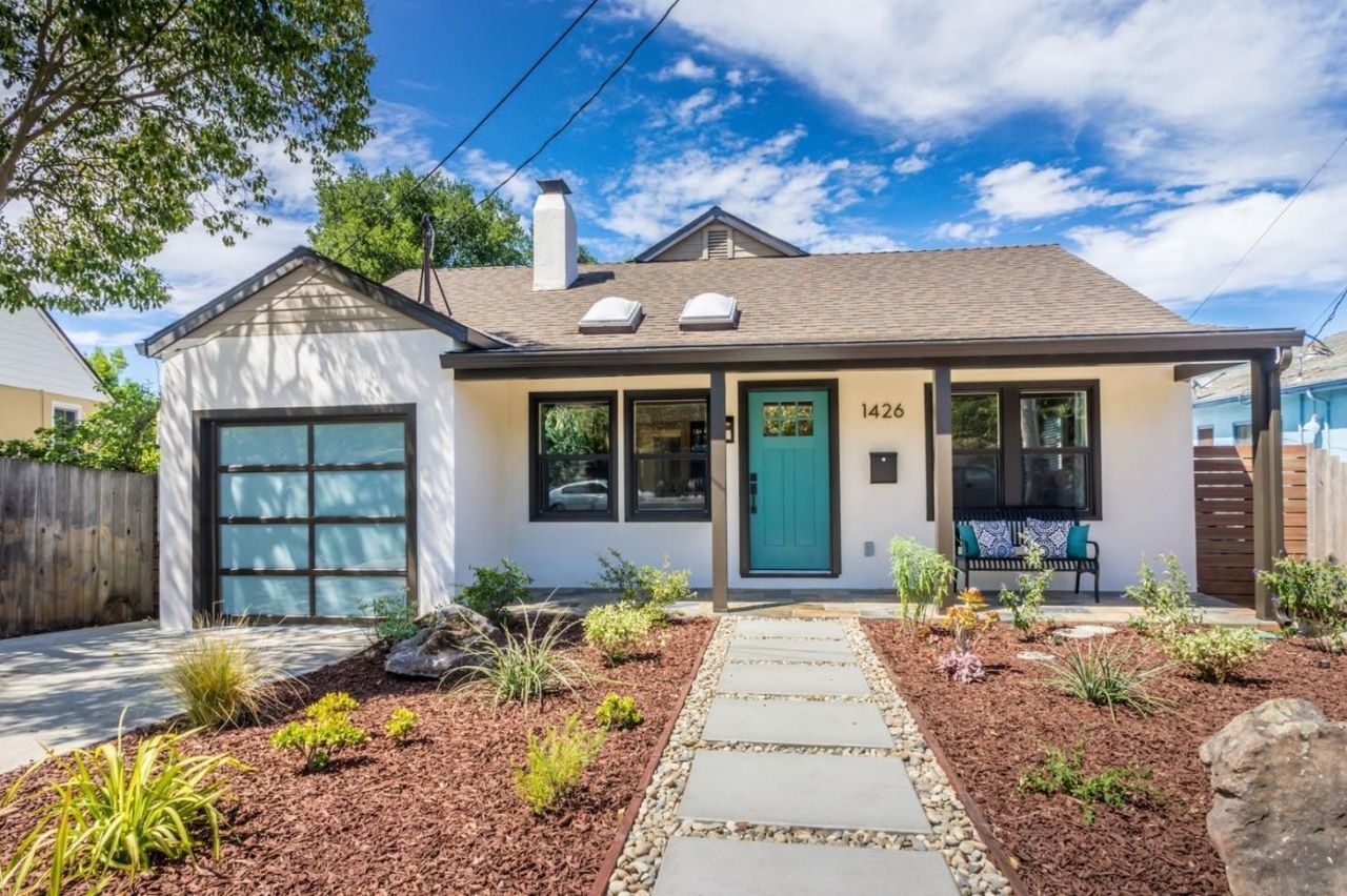 Man in gray suit and blue shirt smiles, headshot against a gray backdrop.