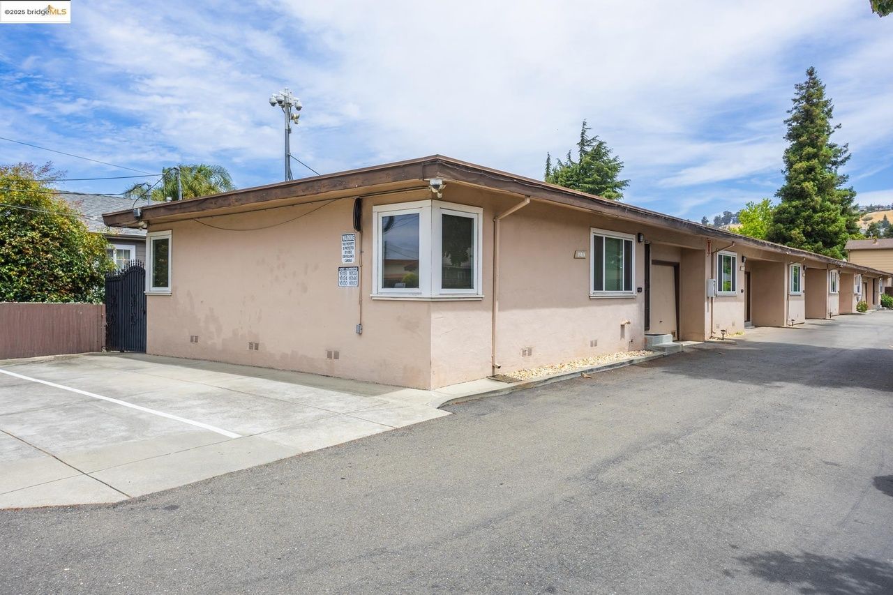 Modern home built from shipping containers with a small yard.