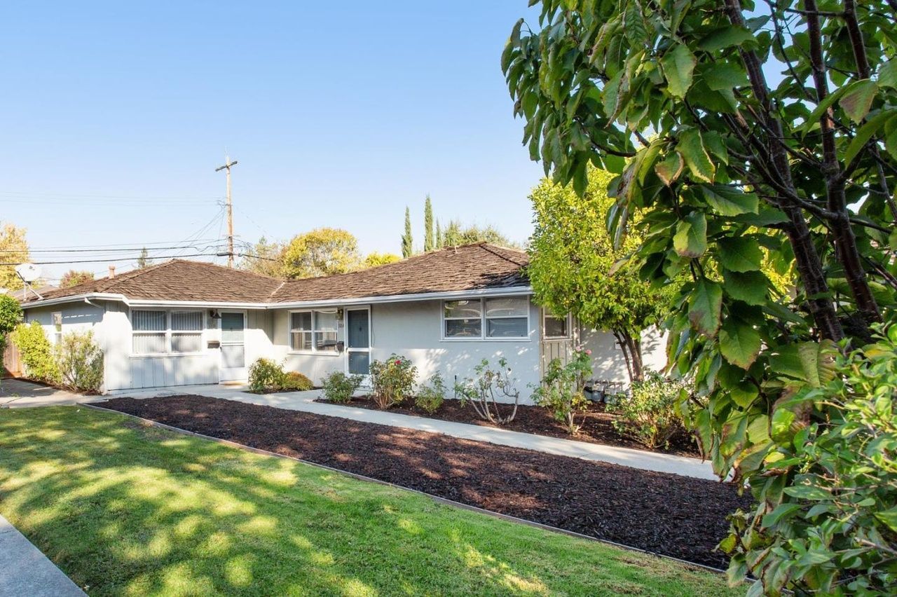 Man in gray suit and blue shirt smiles, headshot against a gray backdrop.