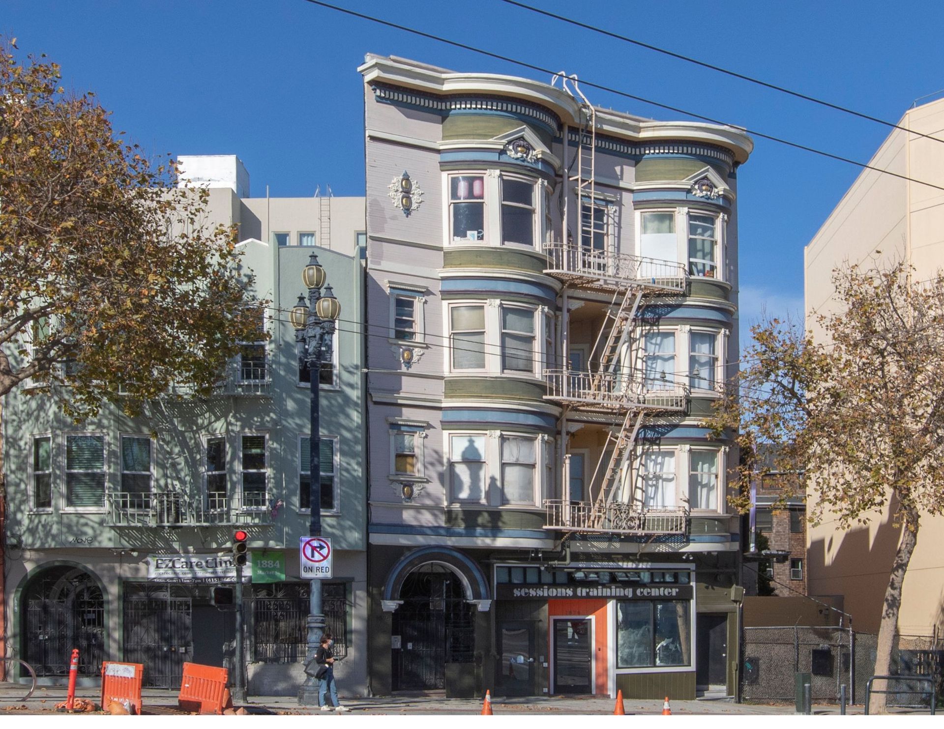 A multi-story building with a fire escape, in an urban setting, with storefronts below.