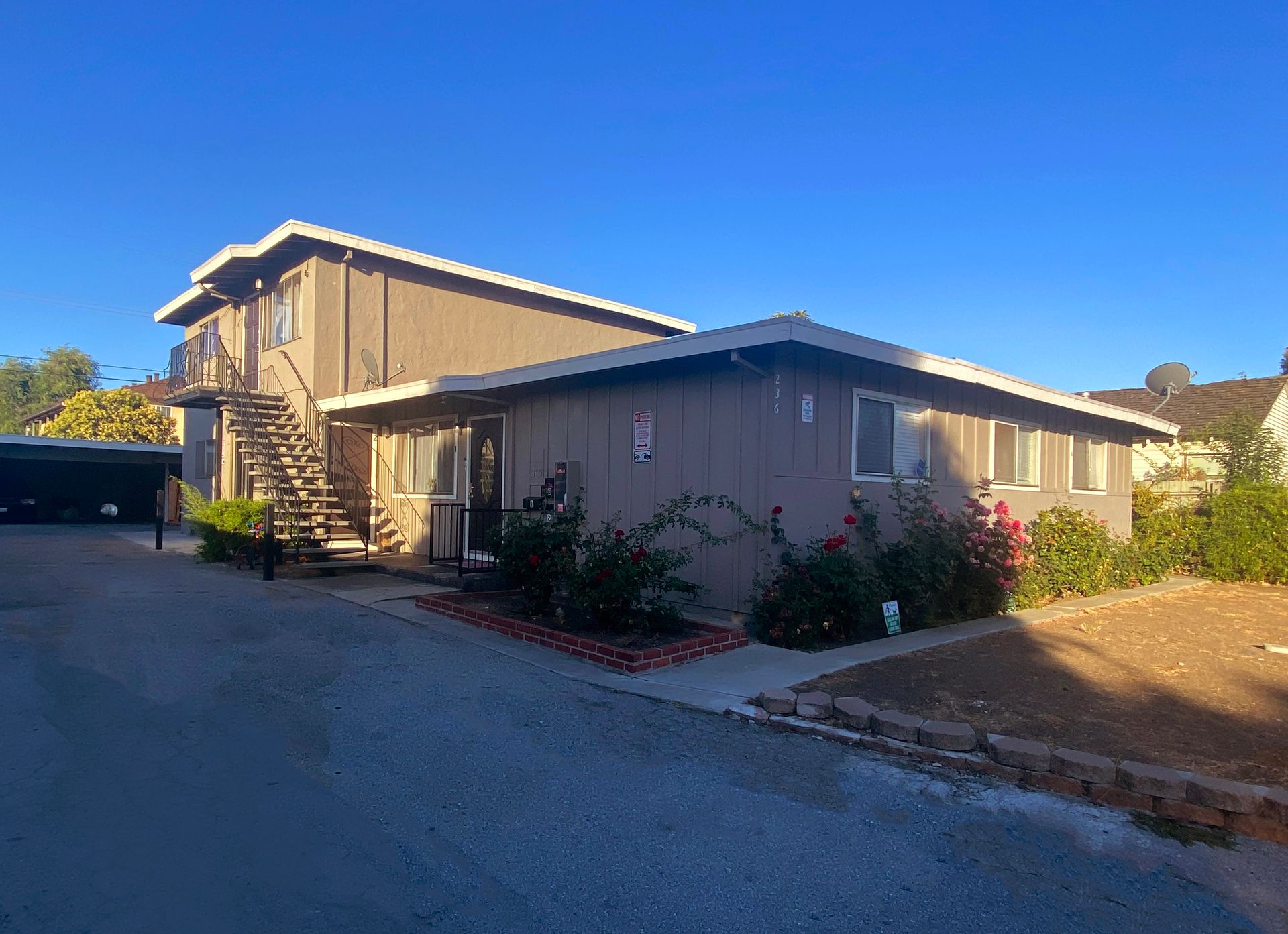Man in gray suit and blue shirt smiles, headshot against a gray backdrop.