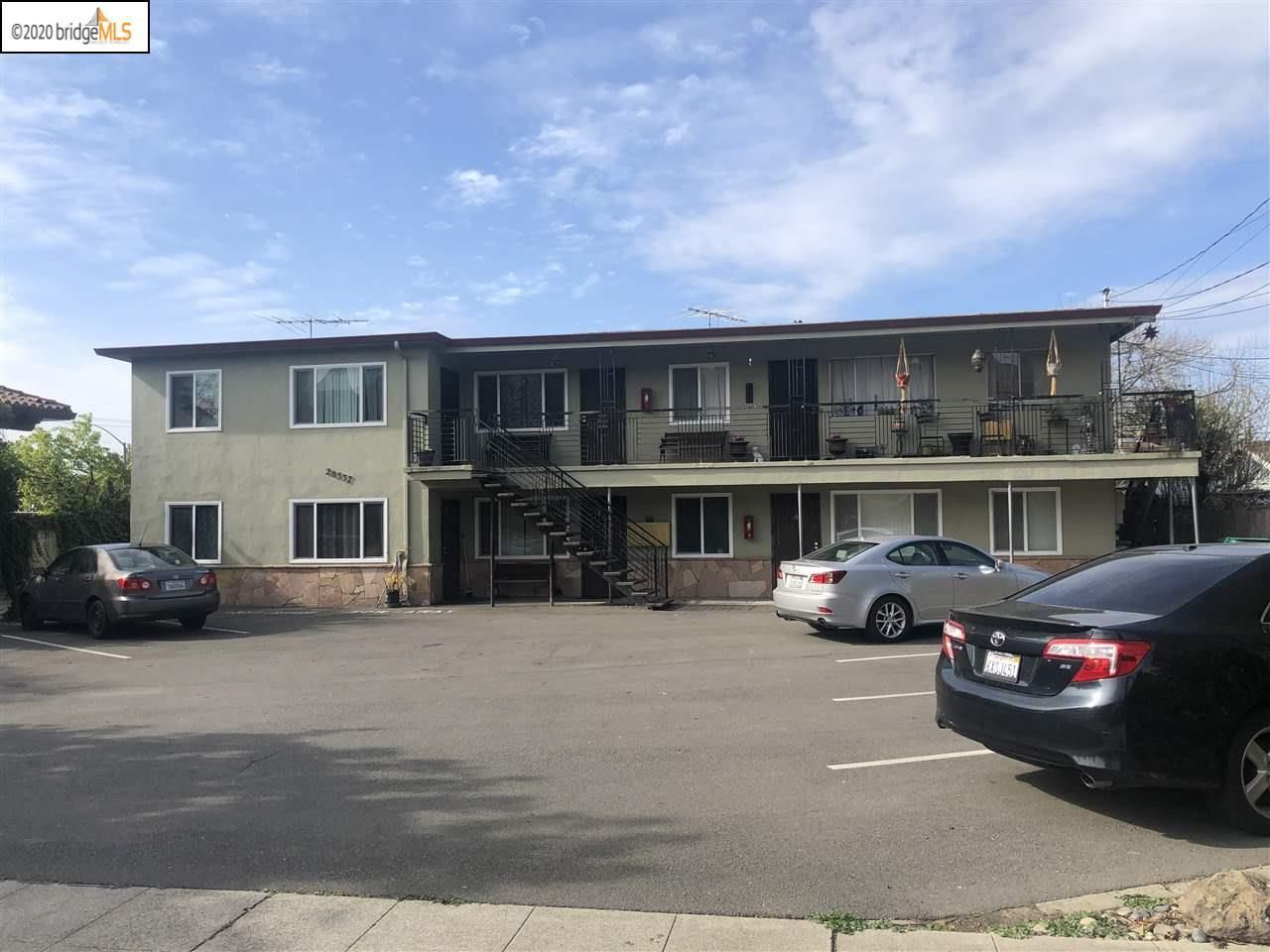 Man in gray suit and blue shirt smiles, headshot against a gray backdrop.