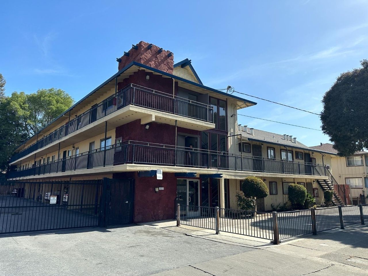 Man in gray suit and blue shirt smiles, headshot against a gray backdrop.