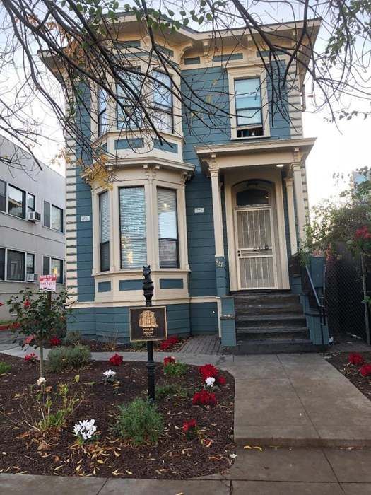 Blue Victorian house with cream trim and garden.
