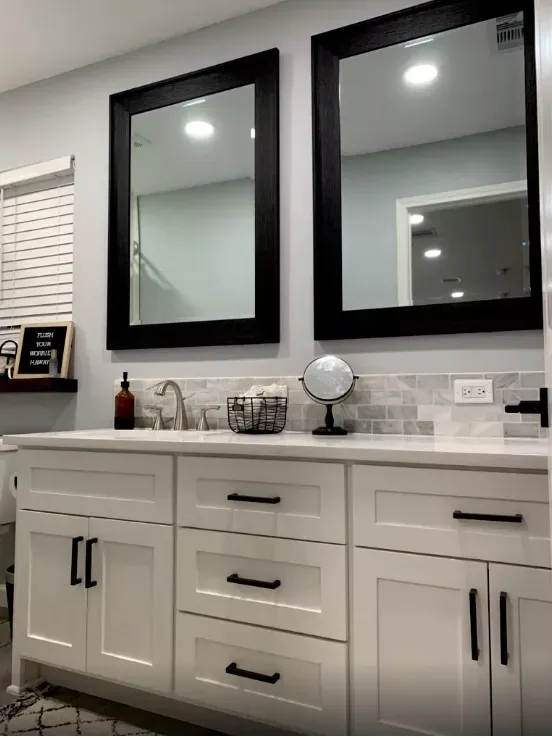 A bathroom with two mirrors and a sink