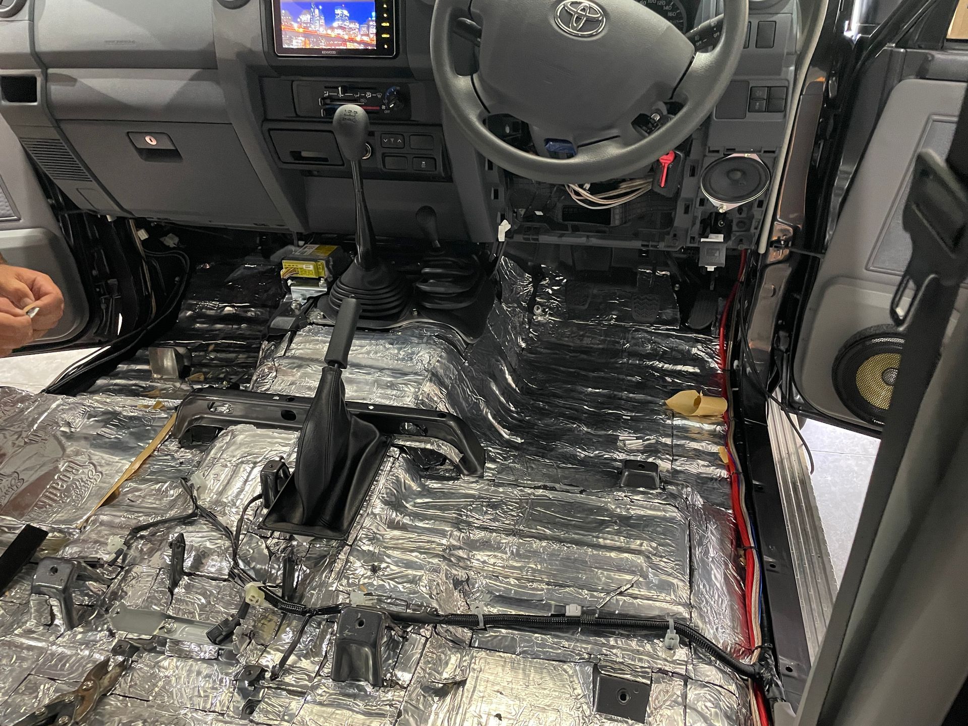 A Tiny House On Wheels Is Parked On The Side Of The Road Near The Ocean — REM Auto Electrics In Wallsend, NSW